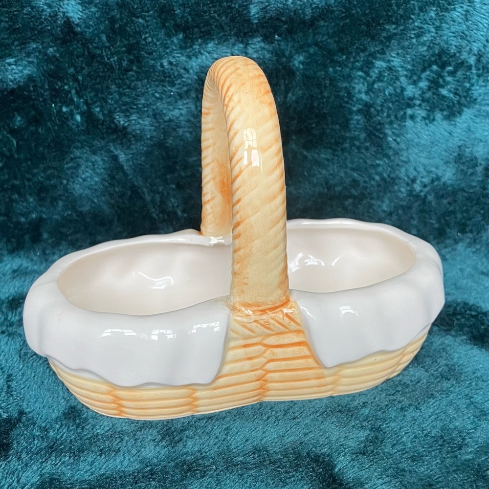 Vintage ceramic basket featuring a woven texture, handle, & ruffled white rim